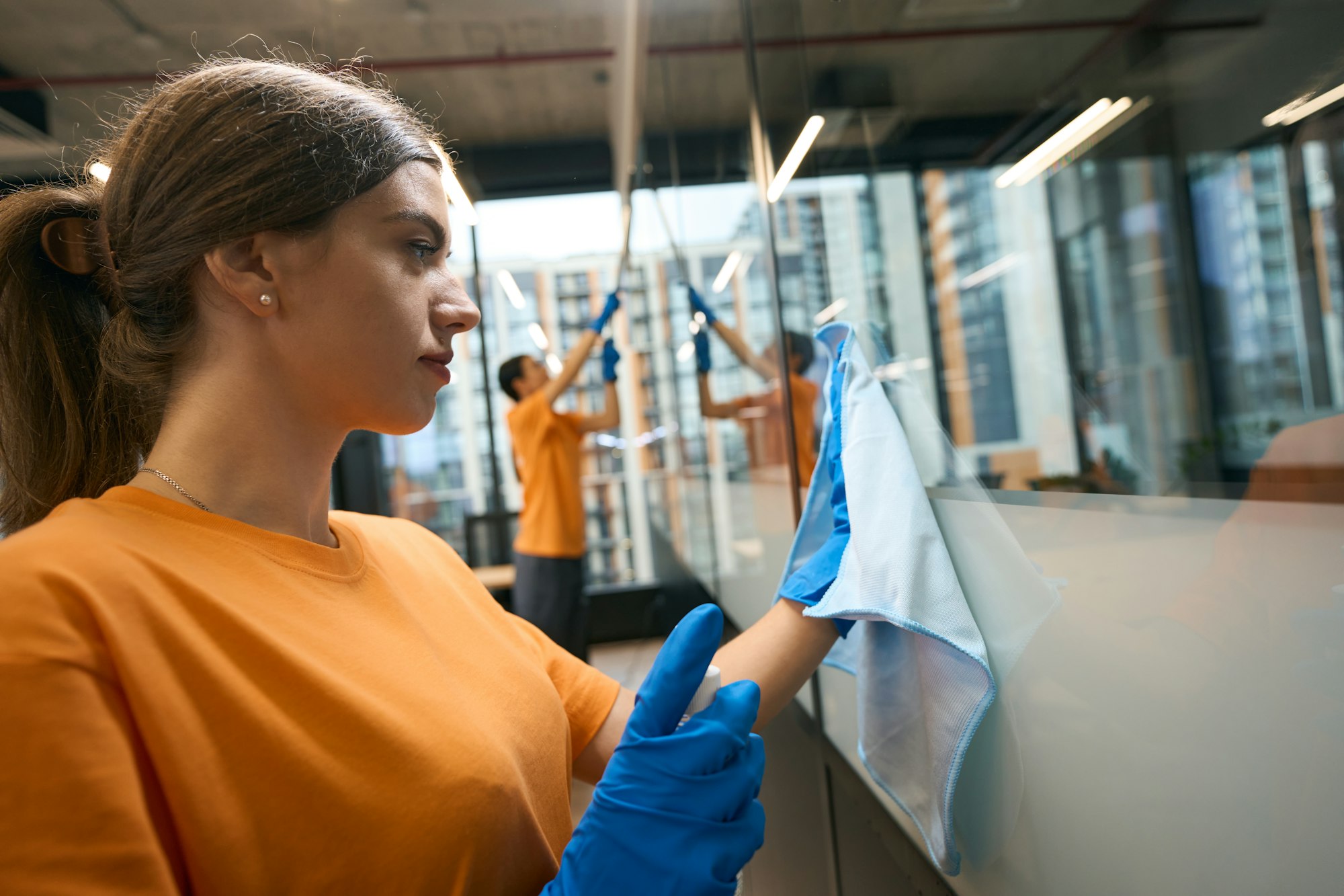 Cleaning service employees use a special glass scraper, special napkins