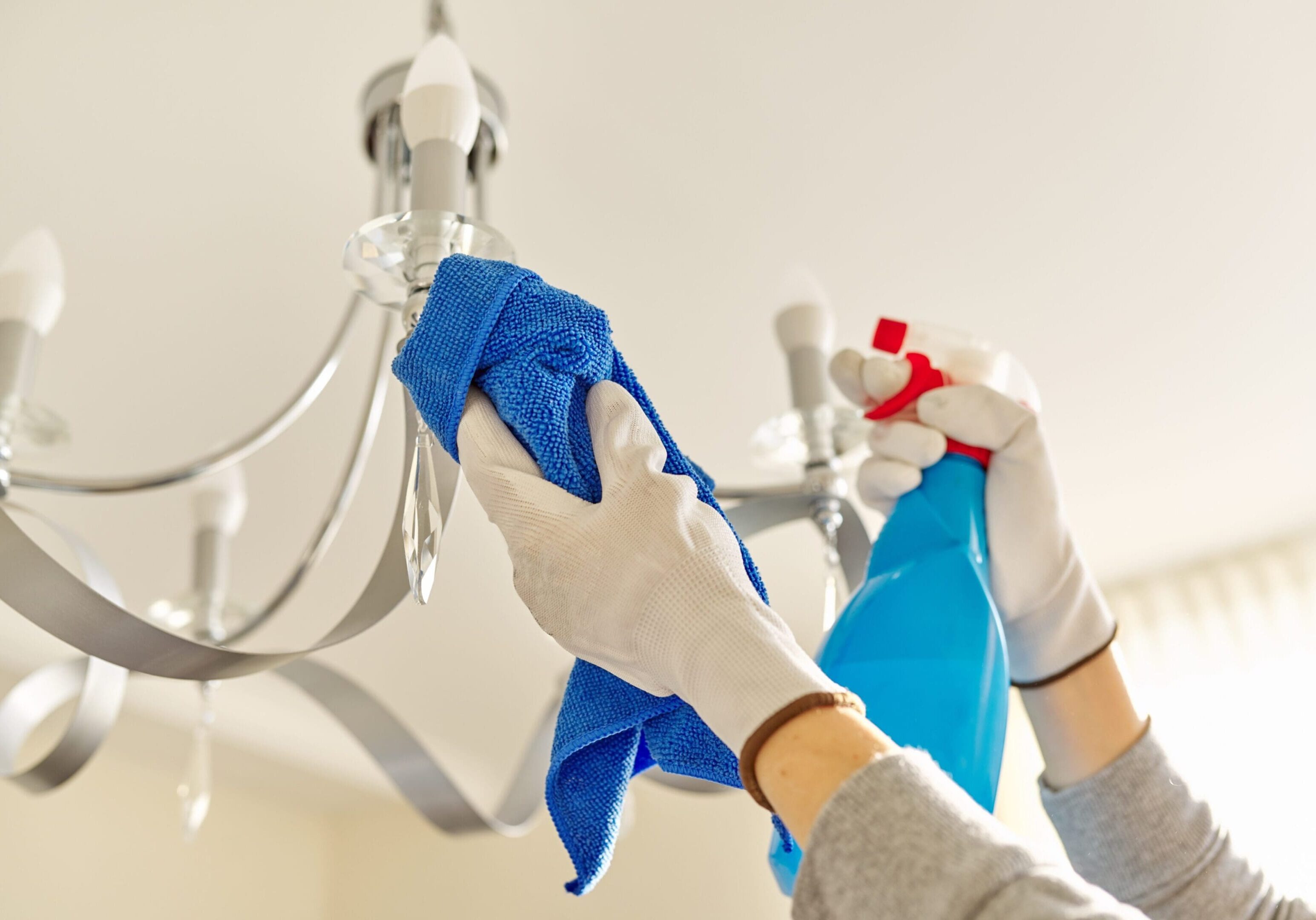 House cleaning, close-up of hands with rag detergent, cleaning and polishing lamp, chandelier